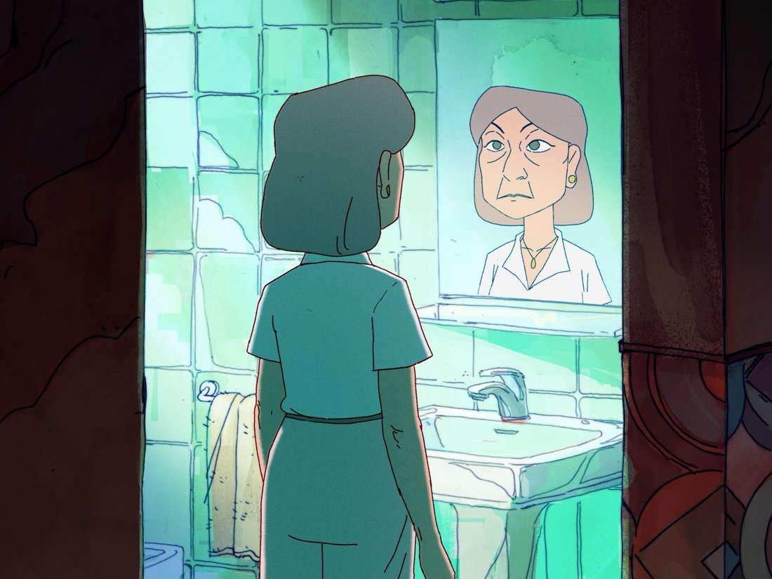 A woman in her late 60s stands in front of a mirror in her bathroom.