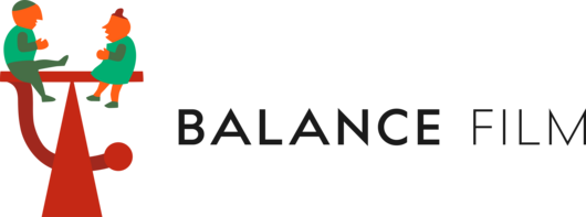 A man and a woman are balancing on a seesaw.