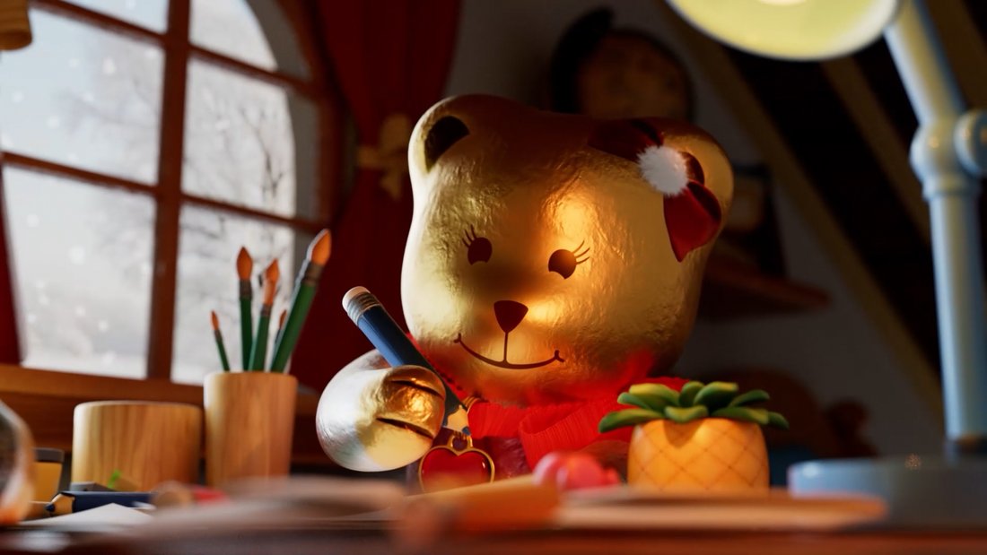 Lindt - Still - A golden Lindt Chocolate Teddy writing a letter.