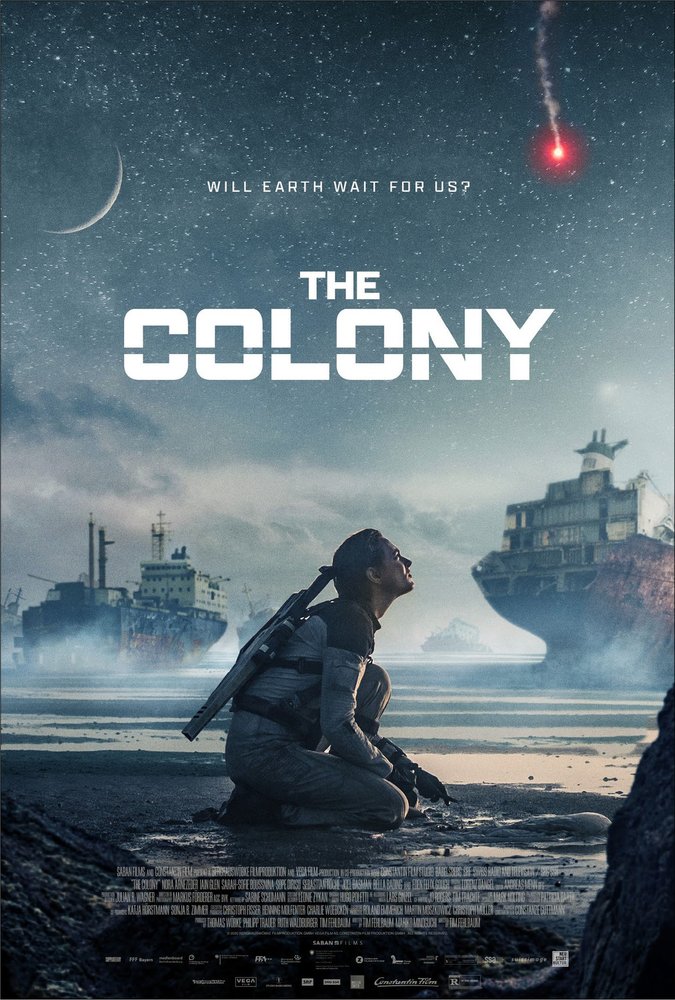 The Colony - Movie Poster - A man dressed in futuristic clothes with a rifle on his back kneeling in the mud in front of some abandoned stranded container ships.